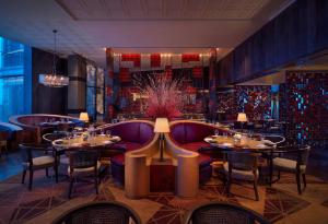 a restaurant with tables and chairs in a room at Grand Hyatt Xi'an in Xi'an