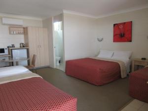 Tempat tidur dalam kamar di Nambour Lodge Motel