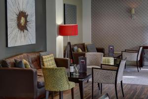 a waiting room with couches and tables and chairs at Best Western Plus Pinewood Hotel, Manchester Airport South Handforth in Handforth