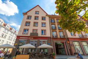 a large building with tables and chairs in front of it at OA - Apartament 50m od Rynku - Old Market Square in Wrocław