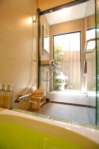baño con bañera, aseo y ventana en Kyoto Nishijin Shichiban Tei (No7), en Kioto