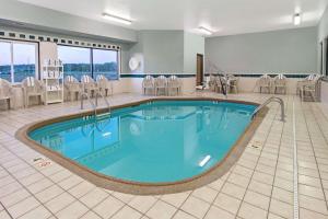 a large pool in a hotel room with chairs at Days Inn by Wyndham Collinsville St Louis in Collinsville