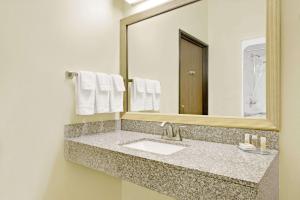 a bathroom with a sink and a mirror at Days Inn by Wyndham Collinsville St Louis in Collinsville