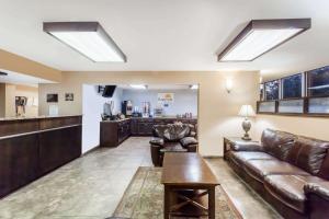 a living room with leather furniture and a bar at Days Inn by Wyndham Jackson in Jackson