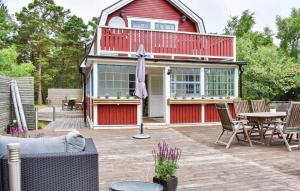 a red house with a patio with a table and chairs at Ljunghusen in Höllviken