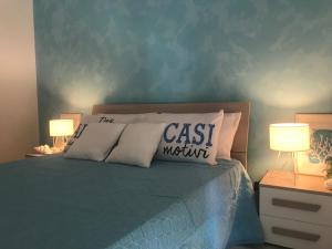 a bedroom with a bed with pillows and two lamps at Apulia Home in Zapponeta