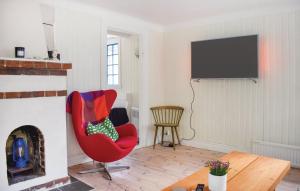 a living room with a red chair and a television at Ljunghusen in Höllviken