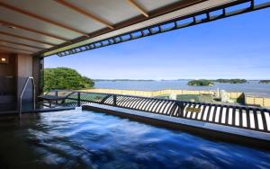 a swimming pool with a view of the water at Hotel Ubudo in Matsushima