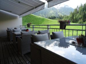 un patio con tavoli, sedie e vista sulle montagne di Apart Tyrol a Umhausen
