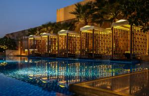 a hotel with a swimming pool at night at Taj City Centre Gurugram in Gurgaon