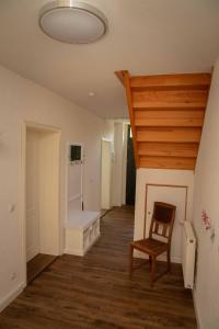 a hallway with a chair and a room with wood floors at Ecke - der Romanik in Quedlinburg