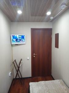 モスクワにあるSloboda Hostel Baumanskayaのベッド2台、壁掛けテレビが備わる客室です。