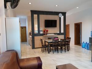 a kitchen and dining room with a table and chairs at Pilly Homestay in Labuan