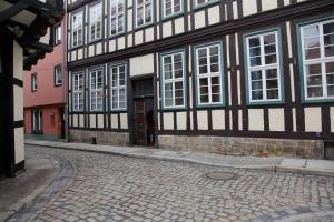 ein Gebäude mit weißen Fenstern und einer Kopfsteinpflasterstraße in der Unterkunft Ferienwohnung im Stieg 4 in Quedlinburg