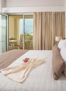 a hotel room with a bed with a flower on it at Kydon The Heart City Hotel in Chania