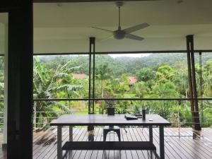a room with a table and a ceiling fan at Cominsia Lodge in Kep
