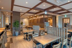 a dining room with wooden tables and chairs at Hotel Route Inn Takamatsu Yashima in Takamatsu