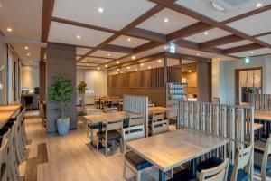 uma sala de jantar com mesas e cadeiras de madeira em Hotel Route Inn Takamatsu Yashima em Takamatsu
