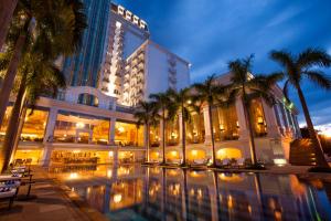 a building with palm trees in front of a pool at Indochine Palace in Hue