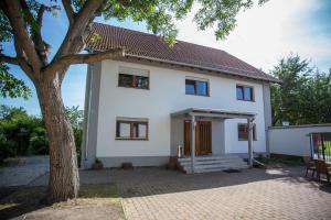 a white house with a tree in front of it at Hotel am Ring in Magdeburg