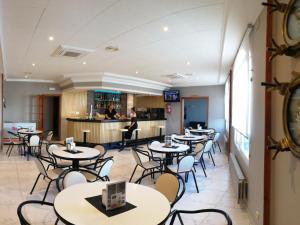a restaurant with tables and chairs and a bar at Hotel Ancora SANXENXO in Granxa