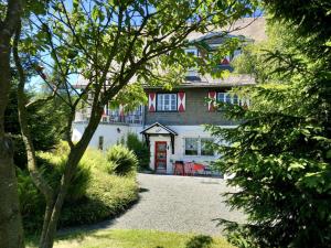 ein Haus mit einer roten Tür und einigen Bäumen in der Unterkunft Haus Schneekappe (Winterberg) in Winterberg