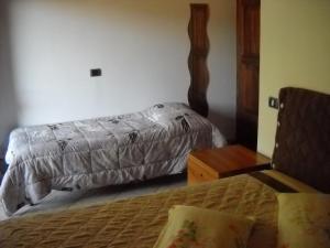 a bedroom with two beds and a night stand and a bedspread at Locanda Contrada dei Fattori in Cairo Montenotte