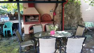 einen Tisch und Stühle mit einem Kamin auf der Terrasse in der Unterkunft Guesthouse Oneiro in Kato Loutraki