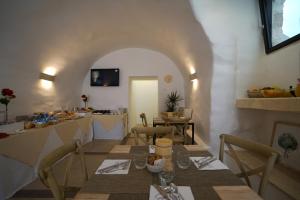 a dining room with a table and chairs and a kitchen at GH Dimora Sant'Anna-Lofts & Apartments in Carovigno