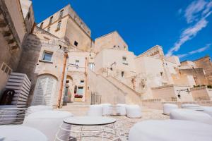 un groupe de tables et de chaises devant un bâtiment dans l'établissement Aquatio Cave Luxury Hotel & SPA, à Matera