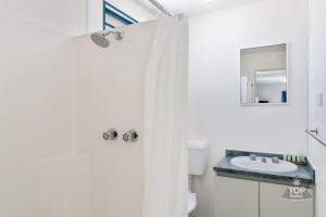a bathroom with a sink, toilet, and shower stall at Denham Seaside Caravan Park in Denham