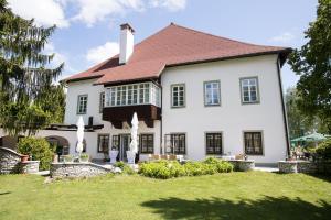 a large white house with a red roof at Suiten Schloss Finkenstein in Gödersdorf