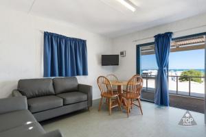 a living room with a couch and a table with chairs at Tasman Holiday Parks - Denham Seaside in Denham