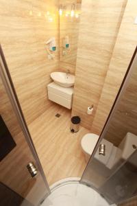 La petite salle de bains est pourvue d'un lavabo et de toilettes. dans l'établissement West Plaza Hotel, à Bucarest