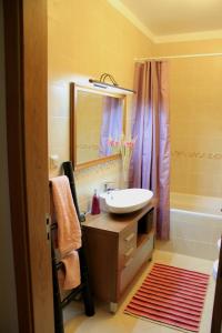 a bathroom with a sink and a mirror and a tub at Sweet Dream House in Faro