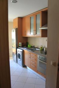 a kitchen with wooden cabinets and a washing machine at Sweet Dream House in Faro