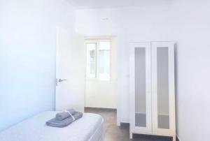アリカンテにあるlovely apartament Alicanteの白い部屋(ベッド1台、鏡付)