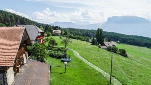 eine Luftansicht eines grünen Feldes mit einem Haus in der Unterkunft Schartnerhof in Klobenstein