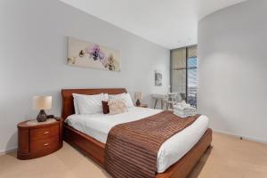 a bedroom with a large bed and a window at Docklands Private Collection - NEWQUAY in Melbourne