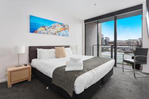 a bedroom with a large bed and a large window at Docklands Private Collection - NEWQUAY in Melbourne