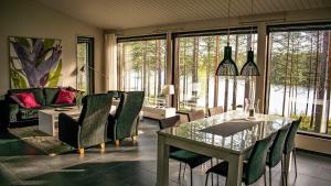 クーサモにあるHarjunrantaのガラスのテーブルと椅子のあるダイニングルーム