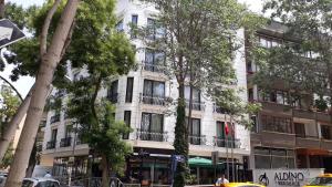 a building on a street with trees in front of it at Aldino Residence in Ankara