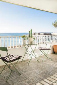einen Balkon mit einem Tisch, Stühlen und Meerblick in der Unterkunft Alicante Ocean View in Alicante