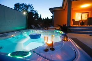 una vasca idromassaggio con candela e 2 bicchieri di Villa Lavender's Breeze a Kornić