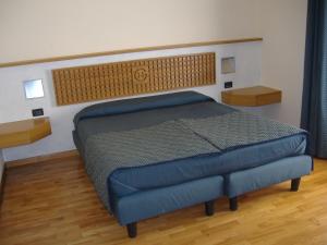 a bedroom with a blue bed in a room at Hotel Ghibellino in Buonconvento