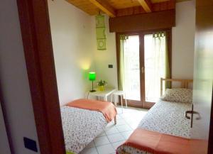 リーヴァ・デル・ガルダにあるAppartamento Betullaのベッドルーム1室(ベッド2台、窓付)