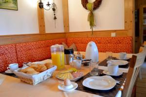 ein Tisch mit Brot und ein Korb mit Orangensaft in der Unterkunft Gästehaus Pfisterer in Bad Schallerbach