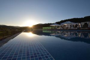 een zwembad met zonsondergang op de achtergrond bij SPA Hotel Infinity Park Velingrad in Velingrad