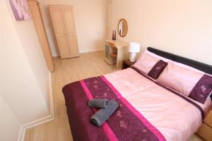 een slaapkamer met een groot bed met roze en paarse lakens bij MARLEY MANSIONs APARTMENTS - KING ST REF : 10/3 in Wallasey