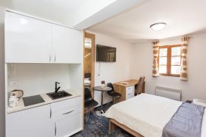 a small bedroom with a bed and a desk at Tilia in Cetinje